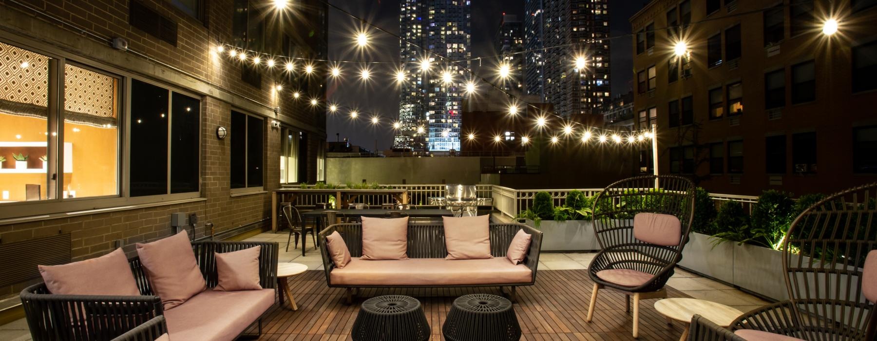 a patio with chairs and a view of a city at night