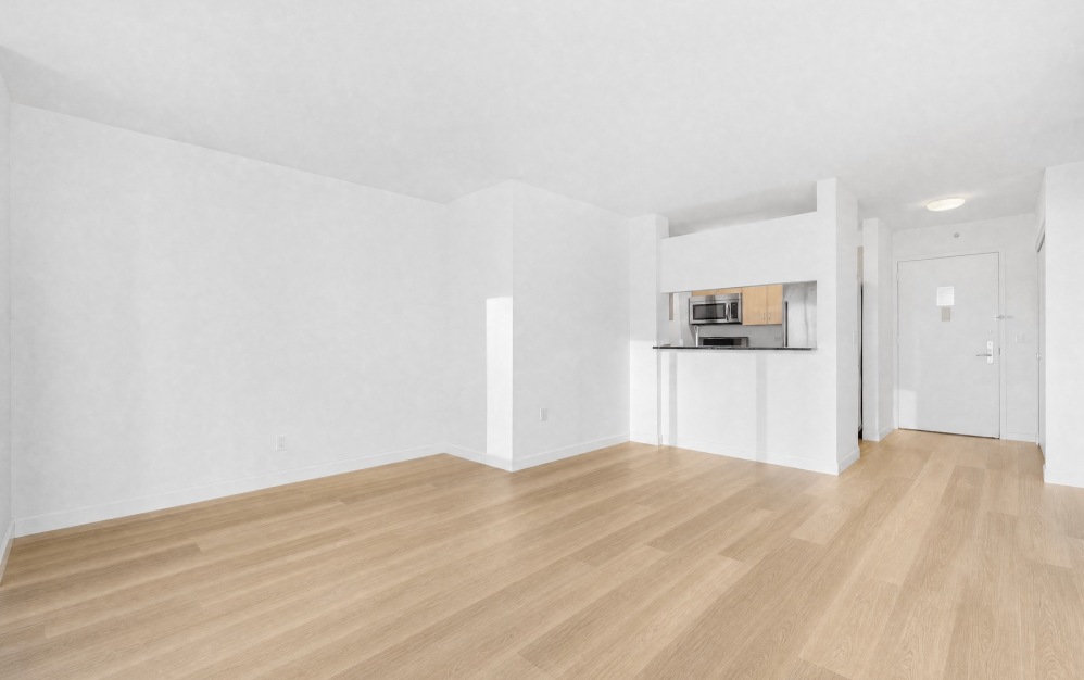large room with wood floors and kitchen