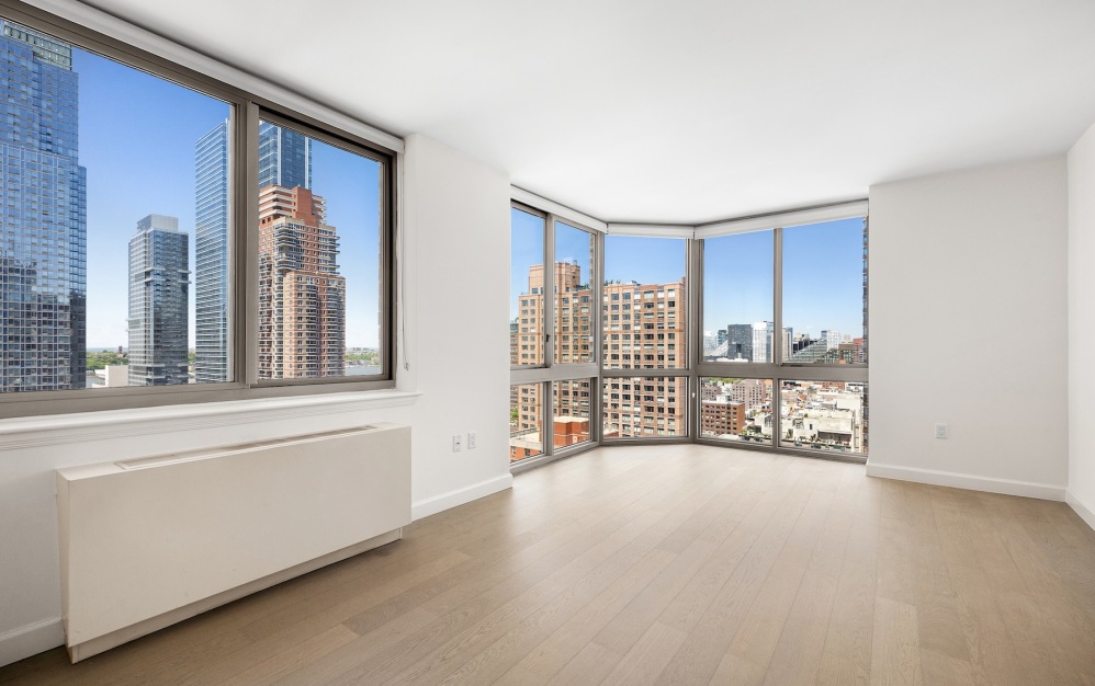 room with wood floors and large windows overlooking a city