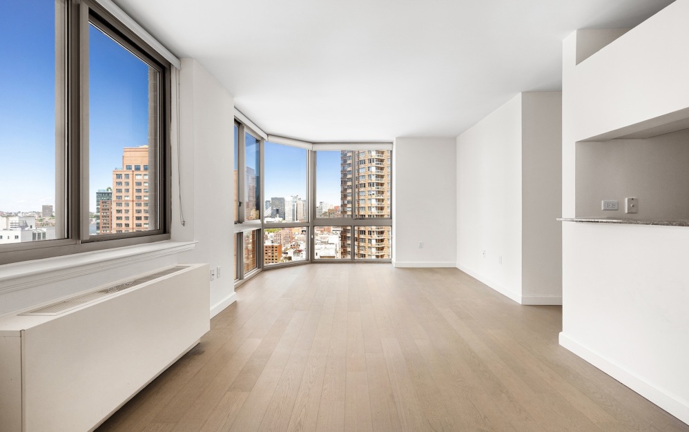 room with wood floors white walls and large windows